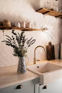 a vase with flowers on a counter next to a sink at Casa do Sossego Monsaraz in Monsaraz