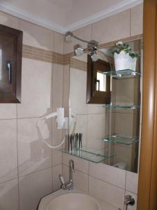 een badkamer met een wastafel en een spiegel bij Palamidi in Agia Paraskevi