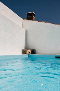 a pool of water next to a white wall at Casa do Sossego Monsaraz in Monsaraz
