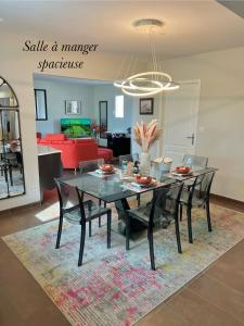 een eetkamer en een woonkamer met een tafel en stoelen bij La Maison du Bonheur in Rochefort
