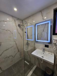 a bathroom with a sink and a shower with a mirror at WG Hotel in Ksamil +37 photos