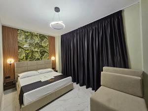 a bedroom with a bed and a couch and a window at WG Hotel in Ksamil