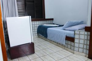 a bedroom with a bed and a whiteboard next to it at Hotel São Charbel in Ubatuba