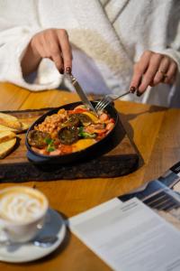 a person eating a bowl of food on a table at Котеджі Лісові Форелі in Yablunytsya