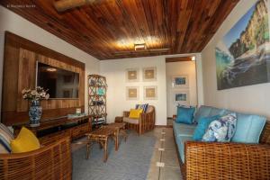 sala de estar con sofá azul y sillas en Pousada da Praia, en Fernando de Noronha