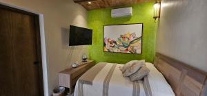 1 dormitorio con paredes verdes y 1 cama con mesa en Real San Pedro. Hotel Boutique, en San Pedro Tesistán