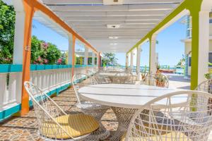 a patio with a white table and chairs at Taino Cove in Treasure Beach
