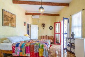 1 dormitorio con 1 cama con una manta colorida en Taino Cove en Treasure Beach