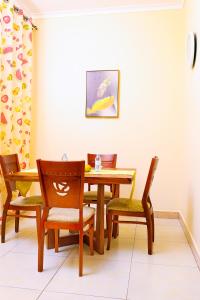 een eetkamer met een houten tafel en stoelen bij Ahva II Residence in Jinja