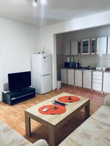 a living room with a table and a kitchen at Apartman Amela in Mostar