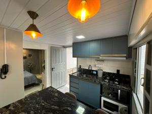 uma cozinha com armários azuis e uma bancada em Aconchegante Quitinete Próximo ao Centro/Criciúma. em Criciúma