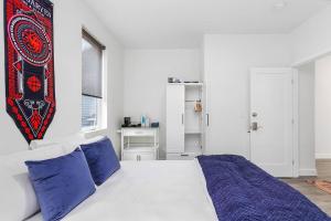 1 dormitorio con cama blanca y almohadas azules en Highgarden The Seat of House Tyrell Sweet Suite en Seattle