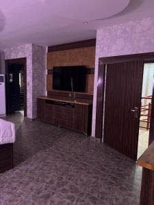 una sala de estar con TV de pantalla plana y una habitación con paredes de color púrpura. en Tourista Travel and Tours 
