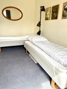 2 camas en una habitación con espejo en la pared en Udsigten, en Rudkøbing