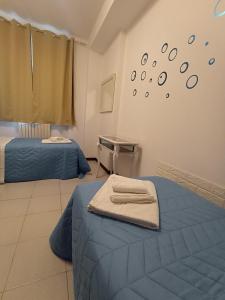 een kamer met twee bedden en een tafel en een klok aan de muur bij Appartamento al mare civico28 in Porto Recanati