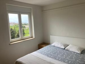 um quarto branco com uma cama e uma janela em Zara em Pula