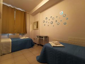een kamer met twee bedden en een klok aan de muur bij Appartamento al mare civico28 in Porto Recanati