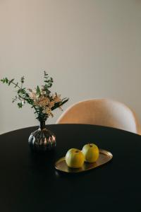 a table with a plate of apples and a vase with flowers at Hotels 705 Porto Prime Home in Porto