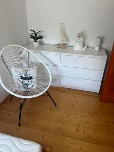 a room with a white chair and a dresser at Rege apartman 2 in Alsóörs