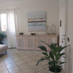 a living room with a table and a plant at Sardegna, House of Flamingos Olbia Apartment in Olbia