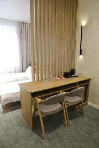 文尼察的住宿－Duboviy Gai Hotel，客房设有一张桌子、两把椅子和一张床