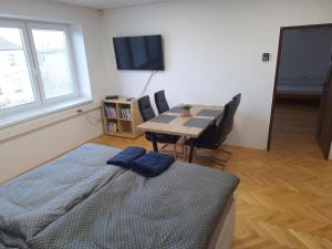 1 dormitorio con cama, mesa y TV en Apartmán Stummerova, en Topoľčany