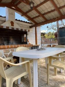 a white table and chairs in front of a fireplace at Μονοκατοικία στη Βόρεια Εύβοια in Kalívia