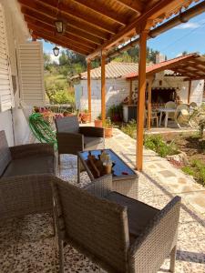 a patio with wicker chairs and a table at Μονοκατοικία στη Βόρεια Εύβοια in Kalívia