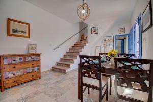 a dining room with a table and chairs and a staircase at Finca el Almendro Archez in Árchez