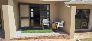 a house with a table and chairs on a patio at Bellville Self Catering in Cape Town
