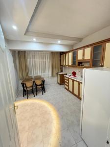 een keuken met een tafel en stoelen en een koelkast bij SiLVER in Pamukkale
