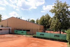 un campo da tennis di fronte a un edificio di Penzion Tsport a Wotitz