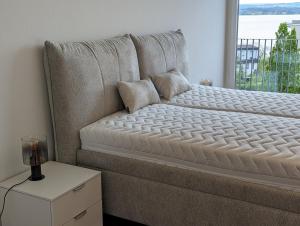 Bett in einem Zimmer mit Fenster in der Unterkunft 4,5 room apartment with lake view in Zug