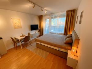 sypialnia z łóżkiem, stołem i oknem w obiekcie Cozy Apartment Bovec w mieście Bovec
