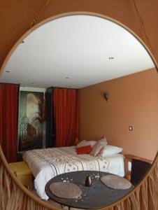 a bedroom with a bed and a mirror at la maison bleue in Ponsas