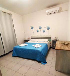een slaapkamer met een bed met blauwe lakens en bomen aan de muur bij Appartamento al mare civico28 in Porto Recanati
