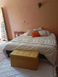 a bedroom with a large bed with an ottoman on it at la maison bleue in Ponsas