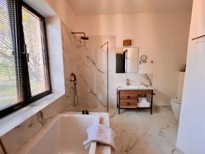 een witte badkamer met een bad en een wastafel bij Pink House in Tsinandali