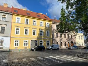 a yellow building with cars parked in a parking lot at HONEST Karlin in Prague +37 photos