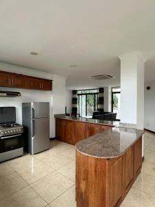 a large kitchen with wooden cabinets and stainless steel appliances at Secluded-Loft-2 BEDROOM-2-Bath in Dar es Salaam