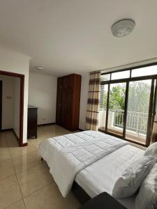 a bedroom with a large bed and a large window at Secluded-Loft-2 BEDROOM-2-Bath in Dar es Salaam
