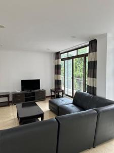 a living room with a couch and a television at Secluded-Loft-2 BEDROOM-2-Bath in Dar es Salaam