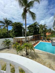 a villa with a swimming pool and palm trees at HUMMINGBIRD CABARETE in Cabarete