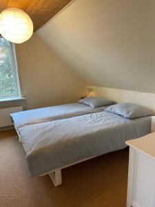 1 Schlafzimmer mit 2 Betten und einem großen Fenster in der Unterkunft Pension Solvang in Rønne