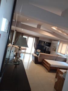 a living room with a couch and a table with a lamp at revisapartments brown in Neos Marmaras