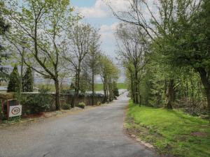 an empty road with trees on the side of it at Middlemuir Retreat in Tarbolton