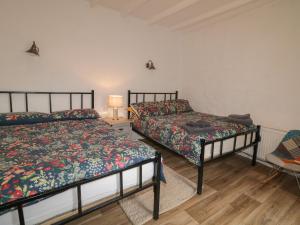 sypialnia z 2 łóżkami, stołem i krzesłem w obiekcie Teach Phaidí Mhóir w mieście Donegal