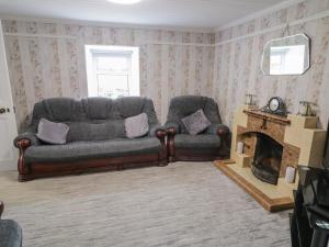 a living room with a couch and a fireplace at Mulroy Cottage in Glinsk