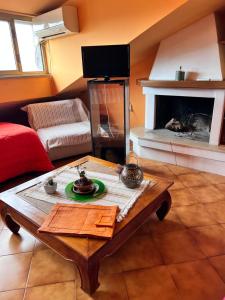 a living room with a table and a fireplace at Giustina - appartamento spazioso e tranquillo - parcheggio privato - "Amore per i cani" - su richiesta c'è posto anche per loro - in Civita Castellana