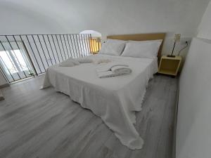 een slaapkamer met een bed met een witte deken erop bij Casa del Grano - Ispica in Ispica